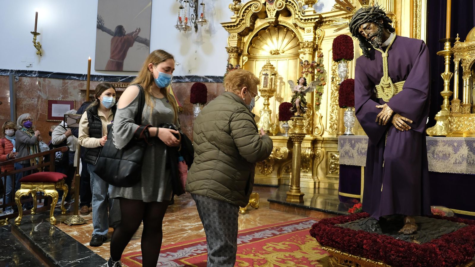 Varios fieles pasan ante el Gran Poder en su veneración