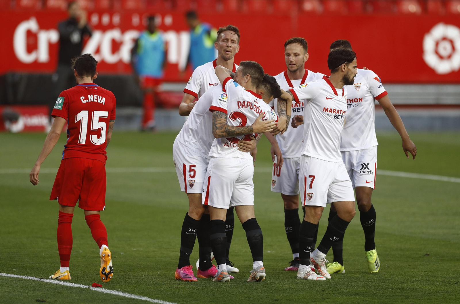 Ocampos se agacha a abrazar al Papu tras el 2-0, ante De Jong, Rakitic, Suso y Fernando.