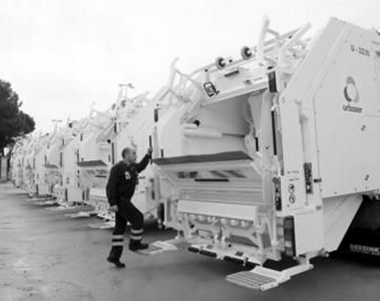 Un trabajador de Urbaser se sube a uno de los camiones de carga trasera ayer presentados.