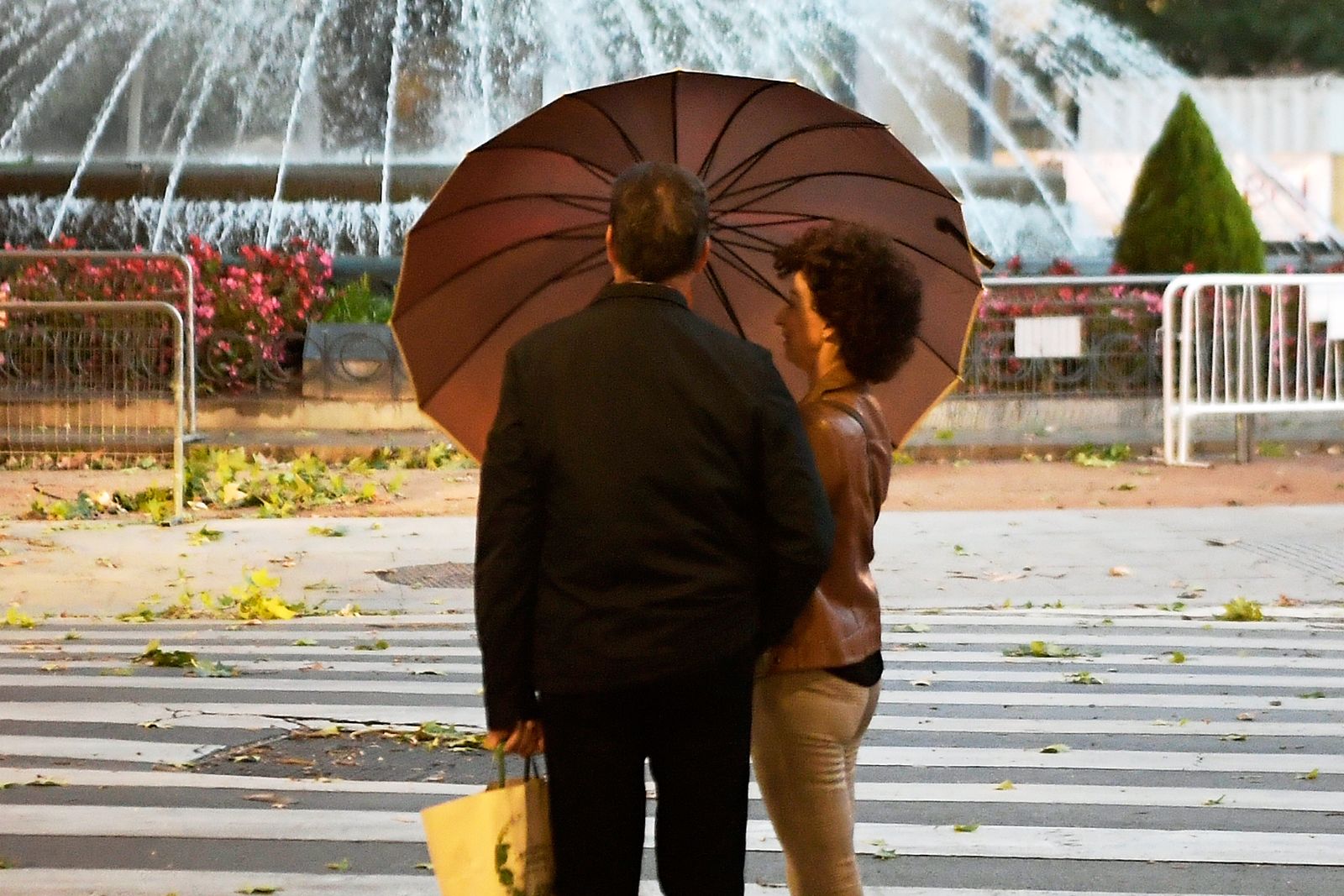 Un matrimonio se protege de la lluvia en el centro de Granada.
