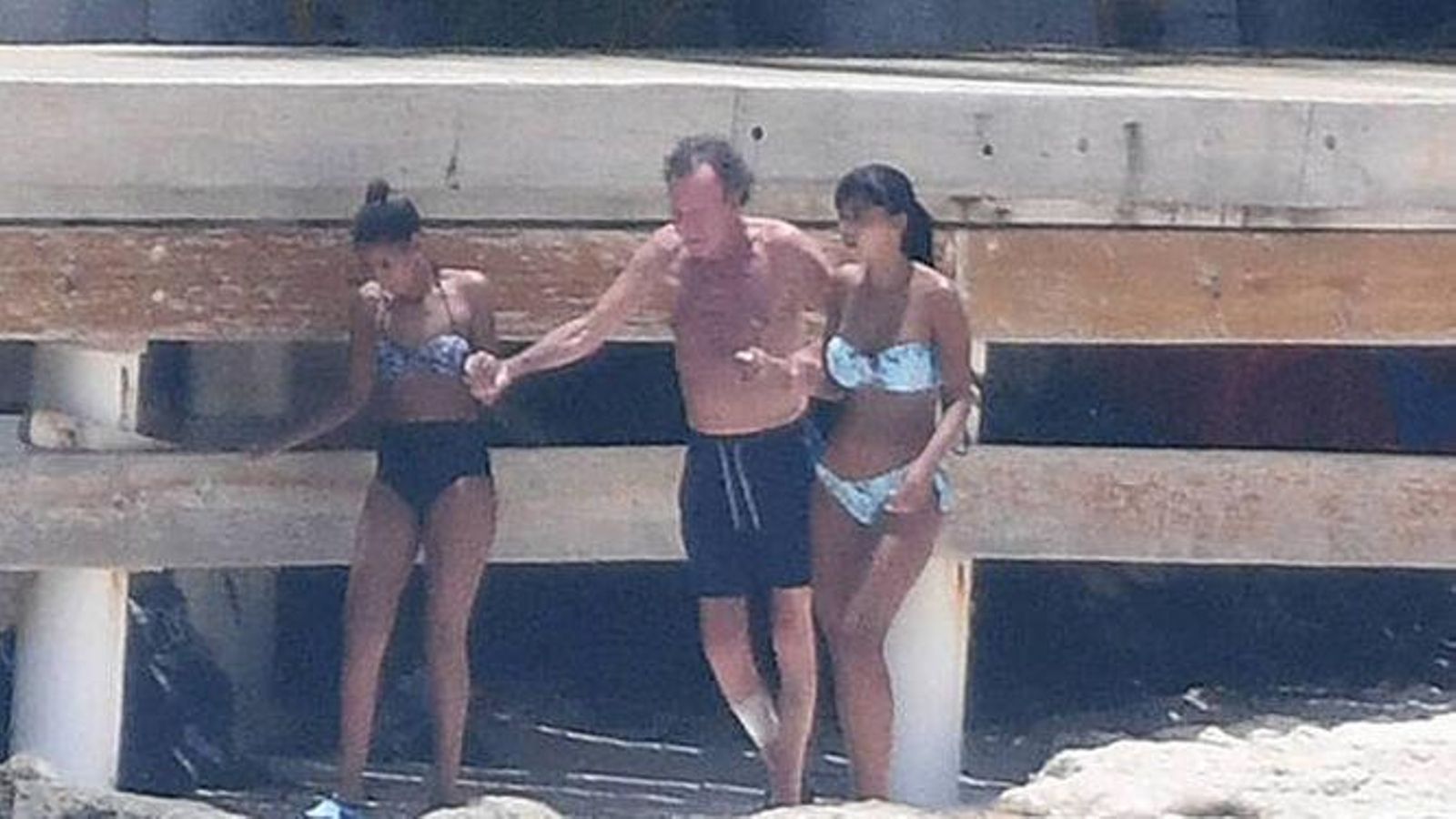 Julio, ayudado a andar por dos mujeres jóvenes, en la foto que dio la vuelta al mundo el verano pasado.