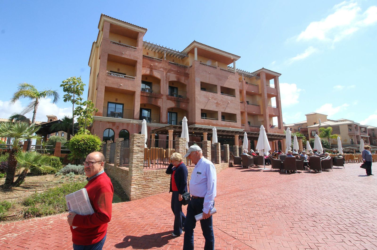 Varios turistas pasean por las inmediaciones de un establecimiento del litoral onubense.