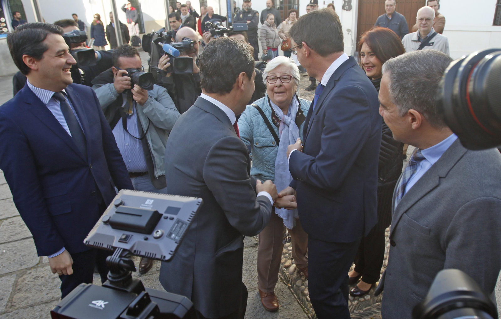 Una señora saluda a Juanma Moreno y a Juan Marín a su llegada al Palacio de Viana, junto a Bellido.