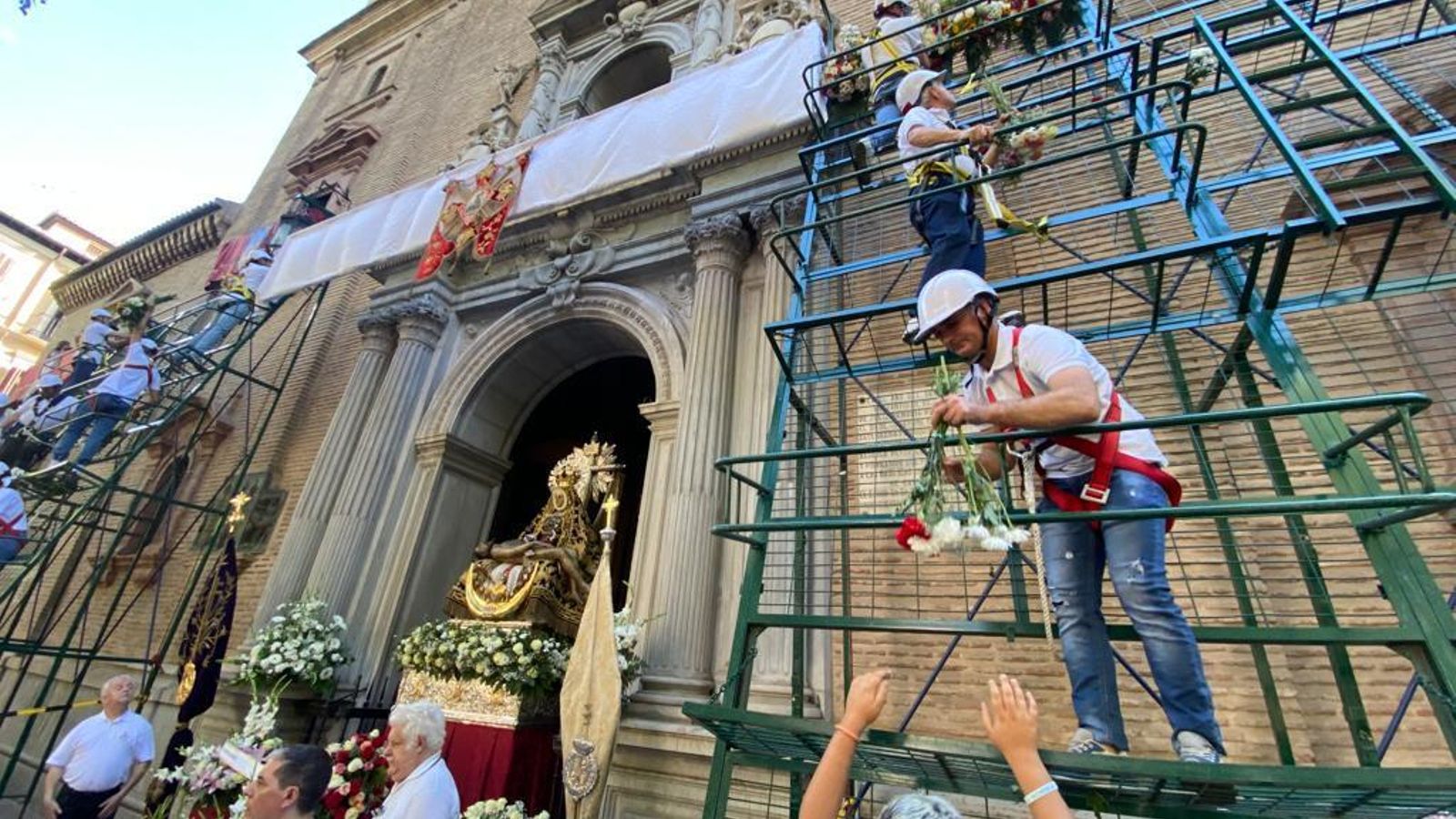 La ofrenda ha congregado a cientos de ciudadanos que hacían cola para ver sus flores colocadas en el mural