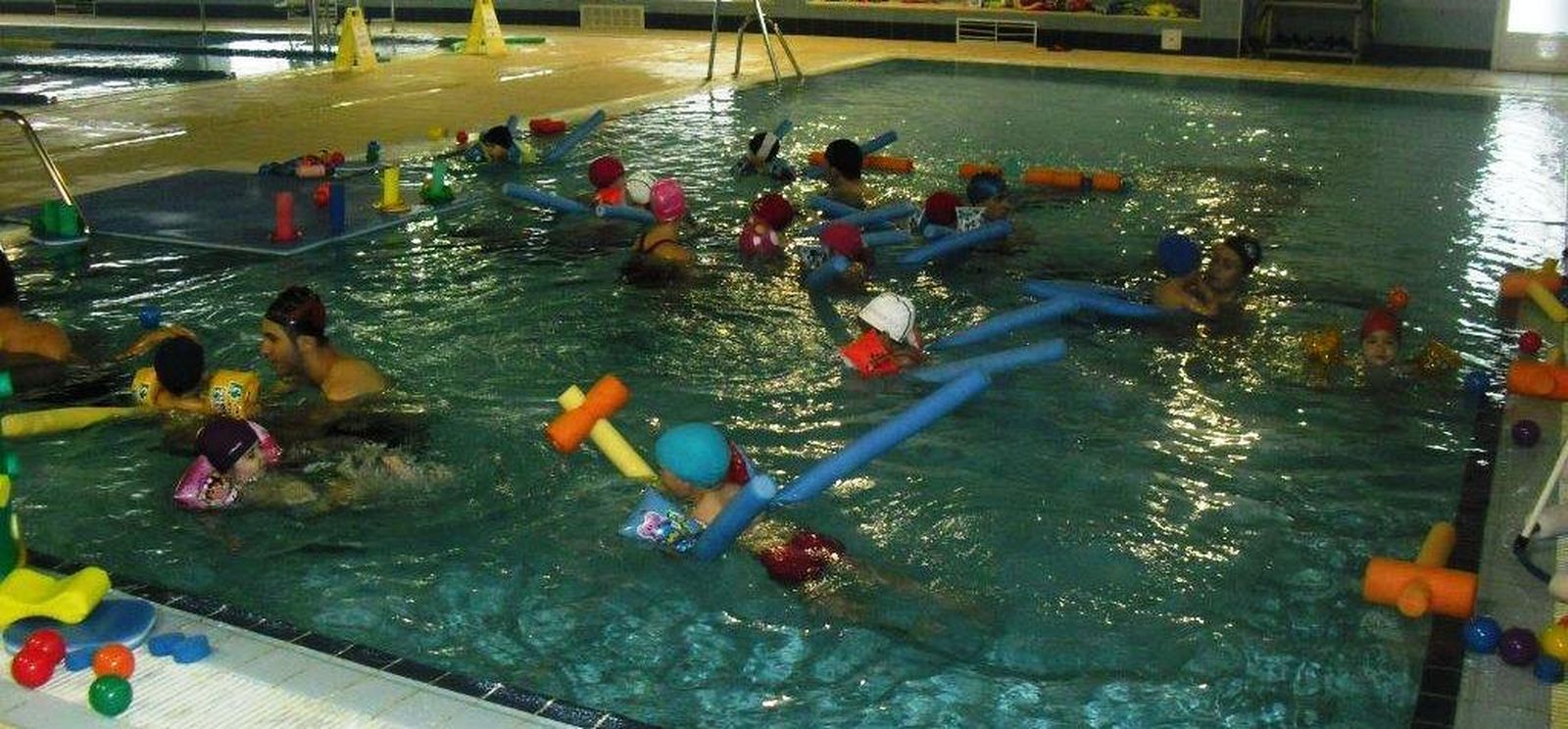 Interior de la piscina con niños jugando en ella.