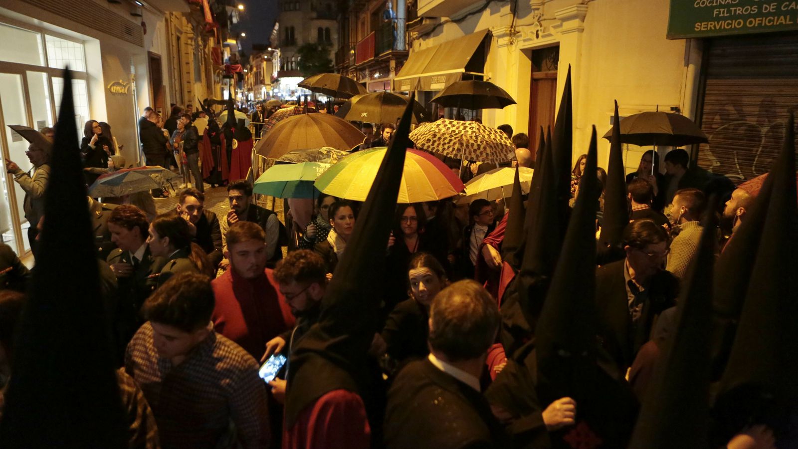Paraguas y nazarenos de vuelta en la puerta de Los Panaderos.