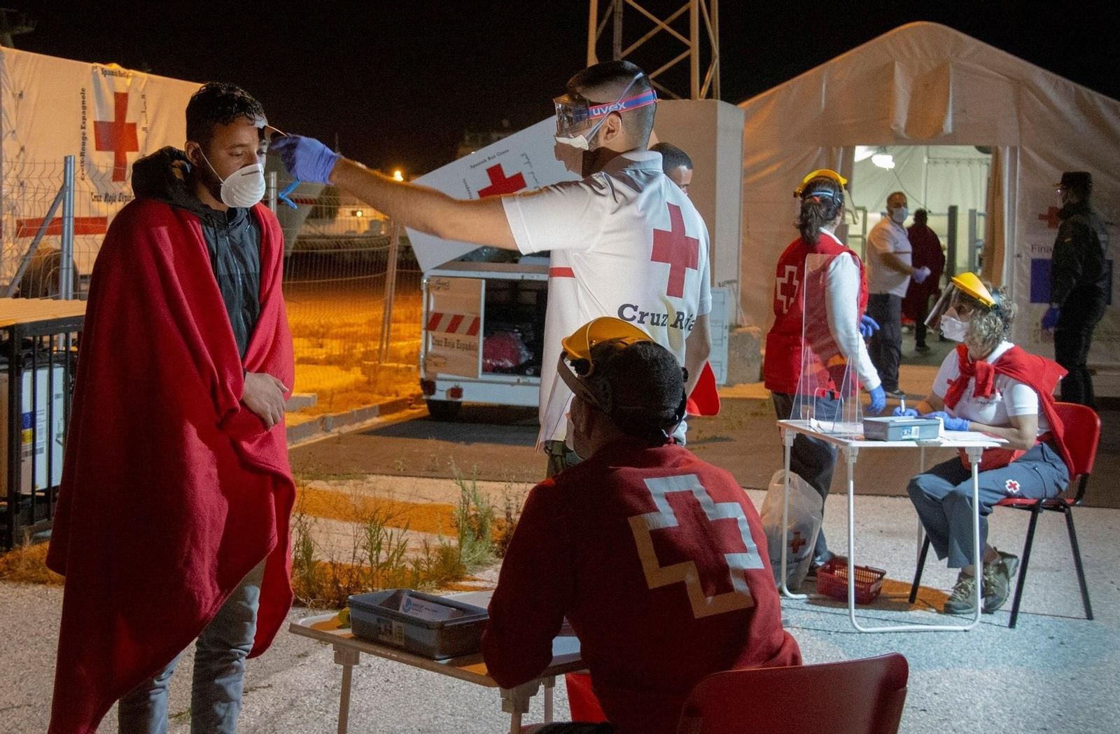 Voluntarios de la Cruz Roja efectúan controles a un grupo de inmigrantes argelinos que llegó al puerto de Motril a finales de mayo.