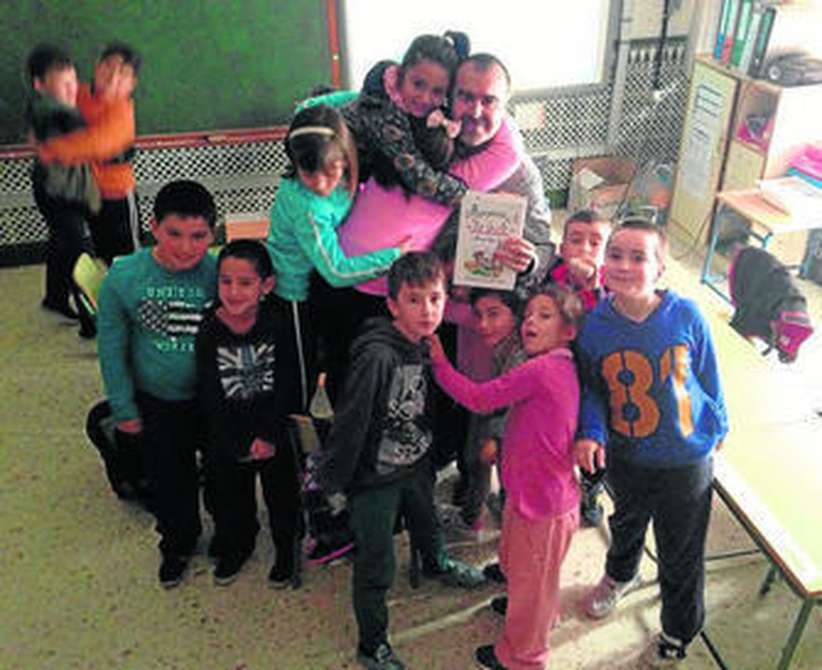 El profesor Francisco Velasco con su nuevo libro en las manos y rodeado de alumnos.