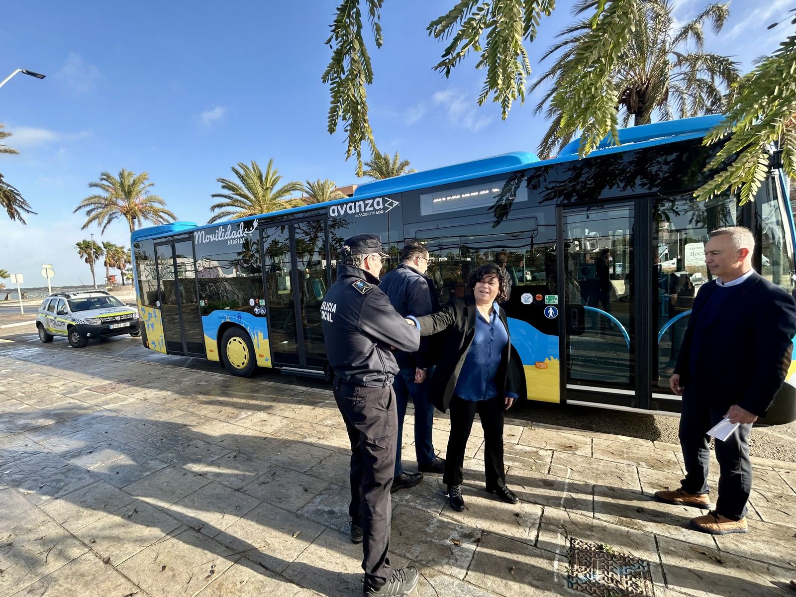 Carmen Álvarez saluda a un policía local en la presentación del nuevo autobús híbrido