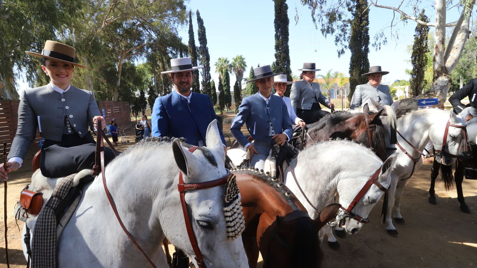 Hombre y mujeres vestidos de corto y amazona a caballo.