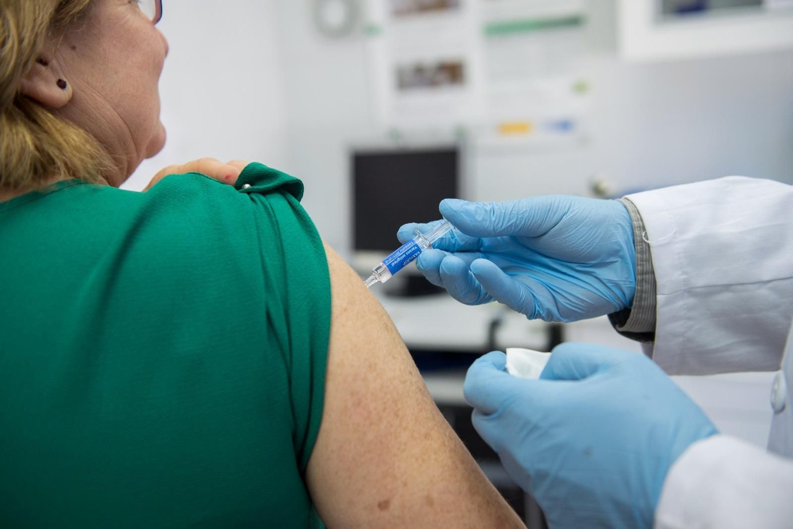 Una enfermera inyecta una vacuna de la gripe a una mujer. Una enfermera inyecta una vacuna de la gripe a una mujer.