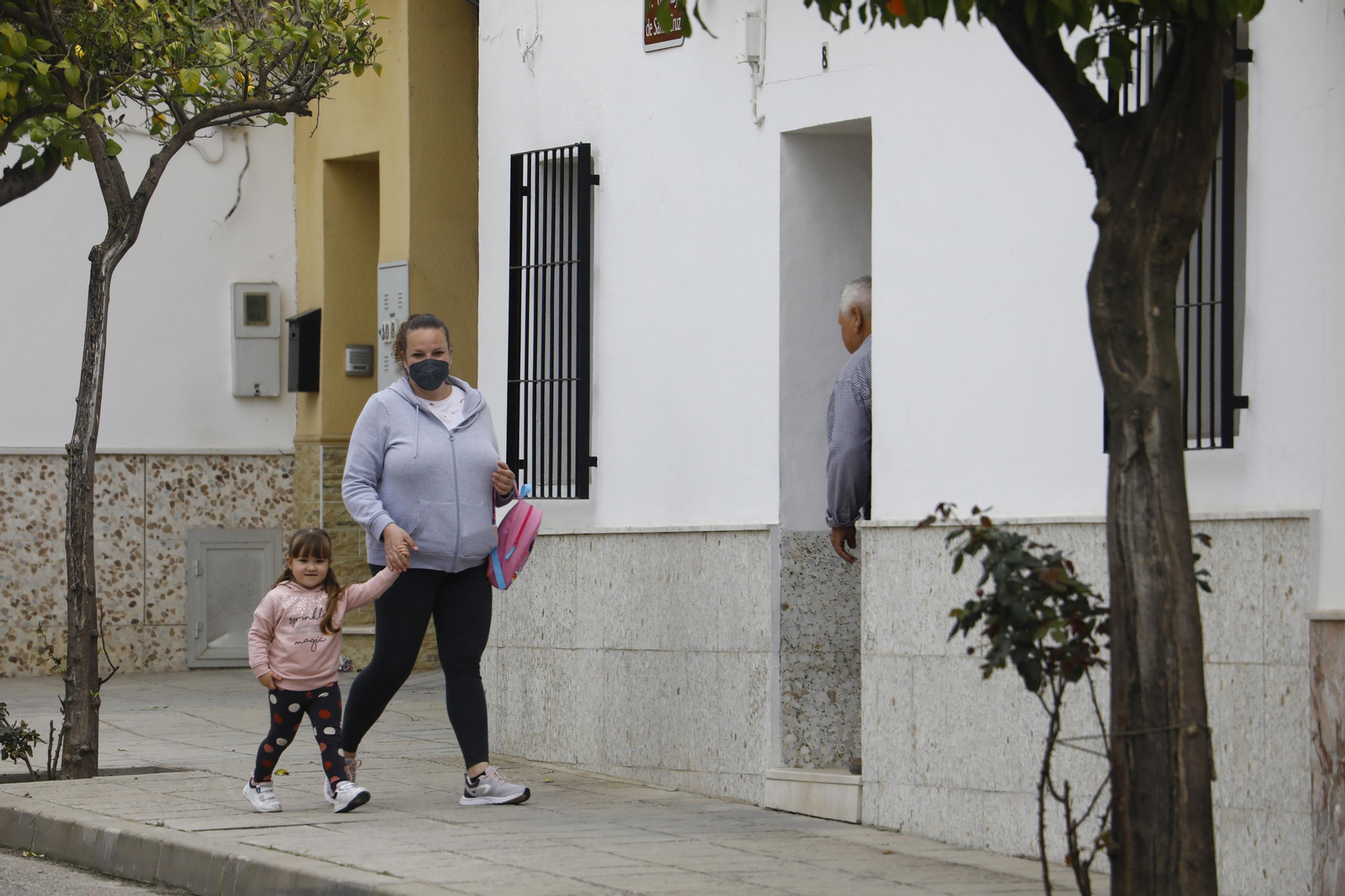 Una madre con su hija camina por una calle de la barriada de Santa Cruz.