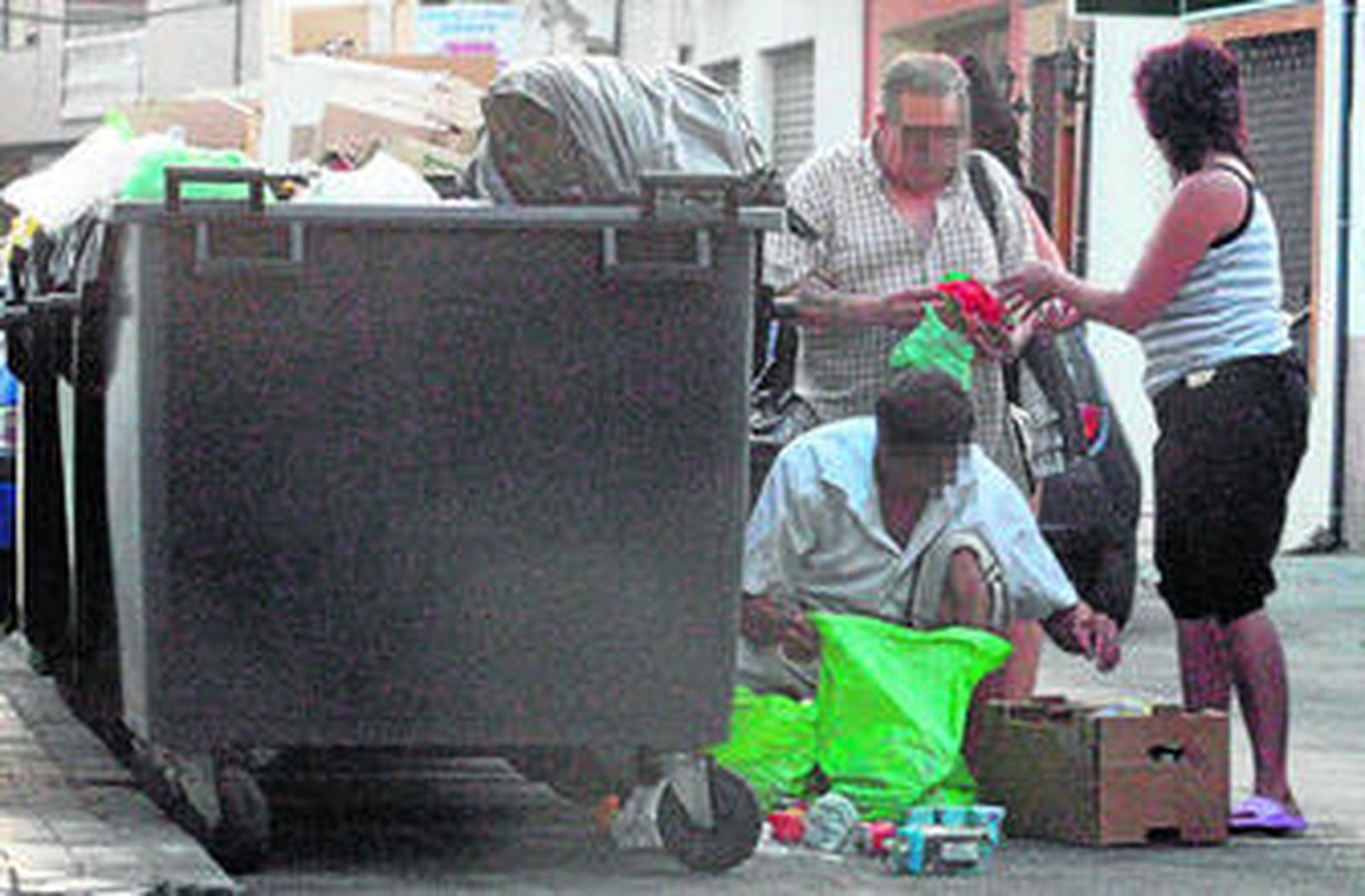 Una familia andaluza, buscando comida en varios contenedores de basura.