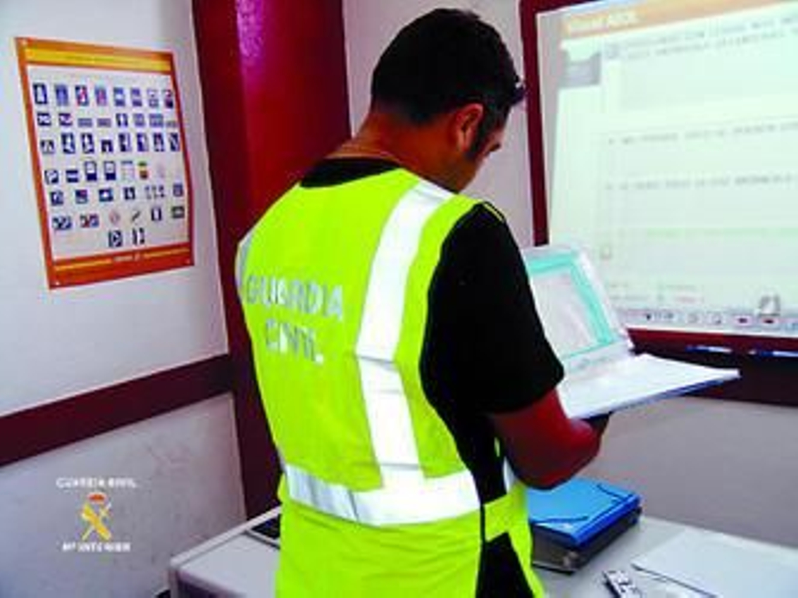 Un agente de la Guardia Civil examina parte de la documentación intervenida en una autoescuela investigada durante la "operación volante".