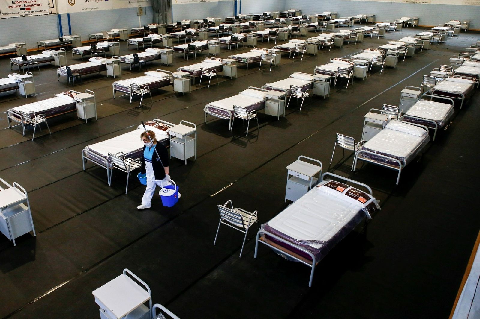 Una limpiadora acondiciona un hospital de campaña.