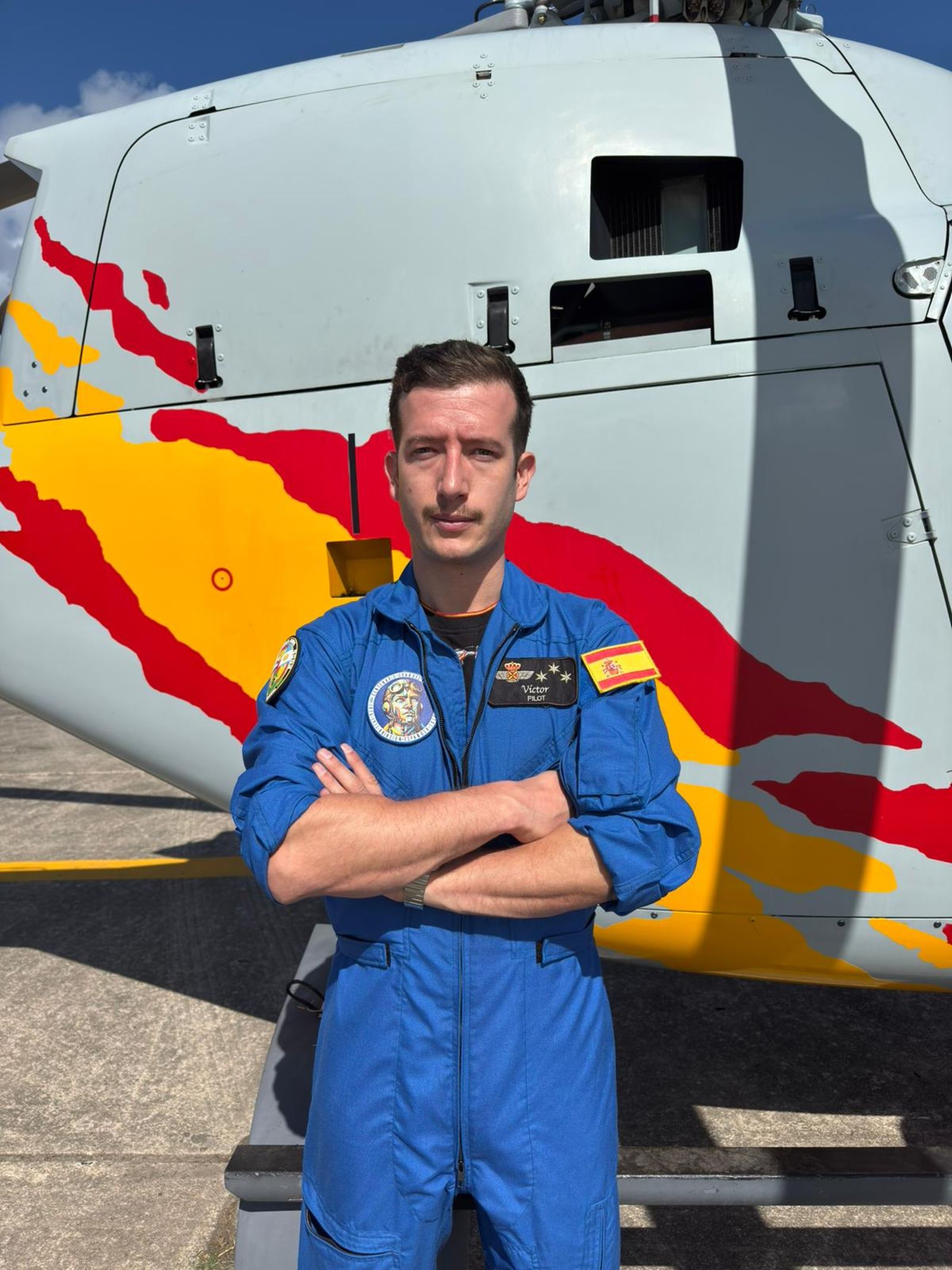 El capitán Fernández posa delante de uno de los helicópteros.