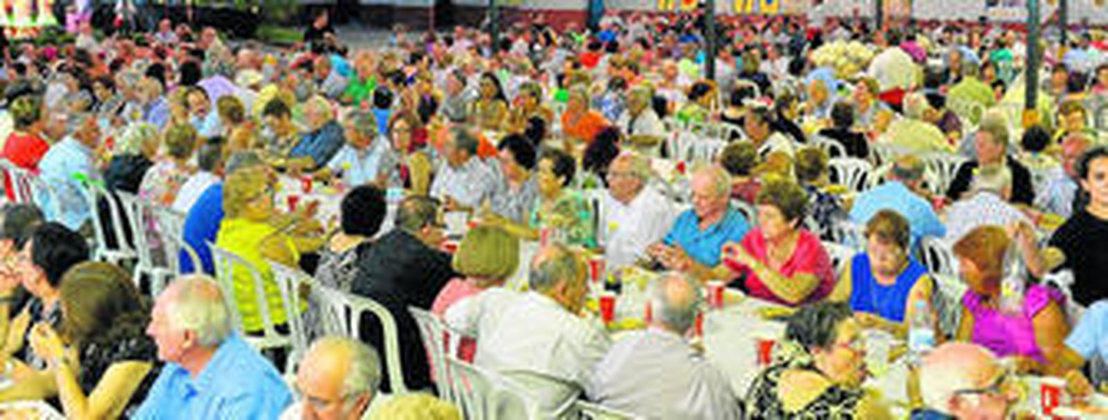 Decenas de malagueños de cada distrito se reúnen para cenar en la caseta El Rengue, en el Cortijo de Torres.
