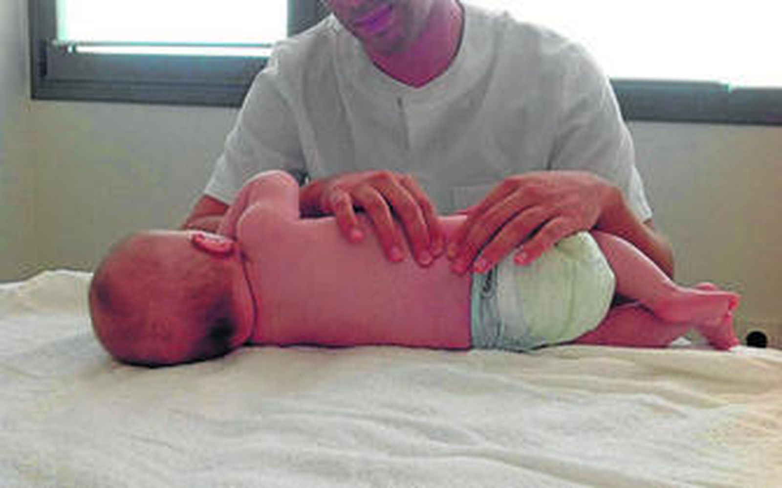 Muñoz aplicando el tratamiento para el cólico lactante a un bebé en Vegasalud.