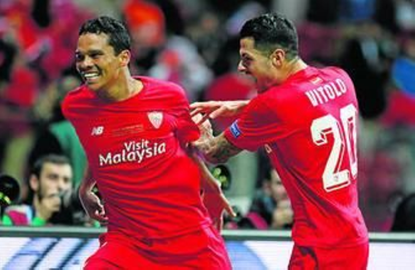 Vitolo intenta agarrar a Bacca para celebrar el definitivo 2-3 en el Estadio Nacional de Varsovial.