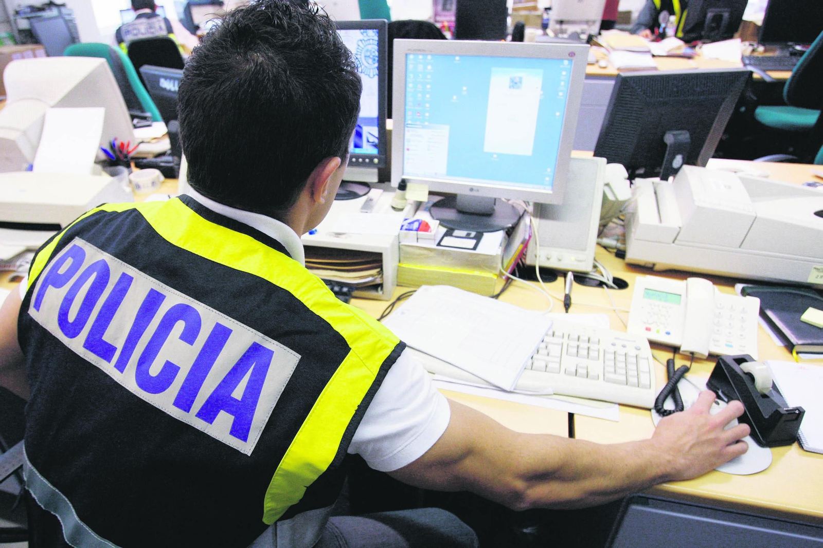 Un agente de la Policía Nacional trabajando con un equipo informático.