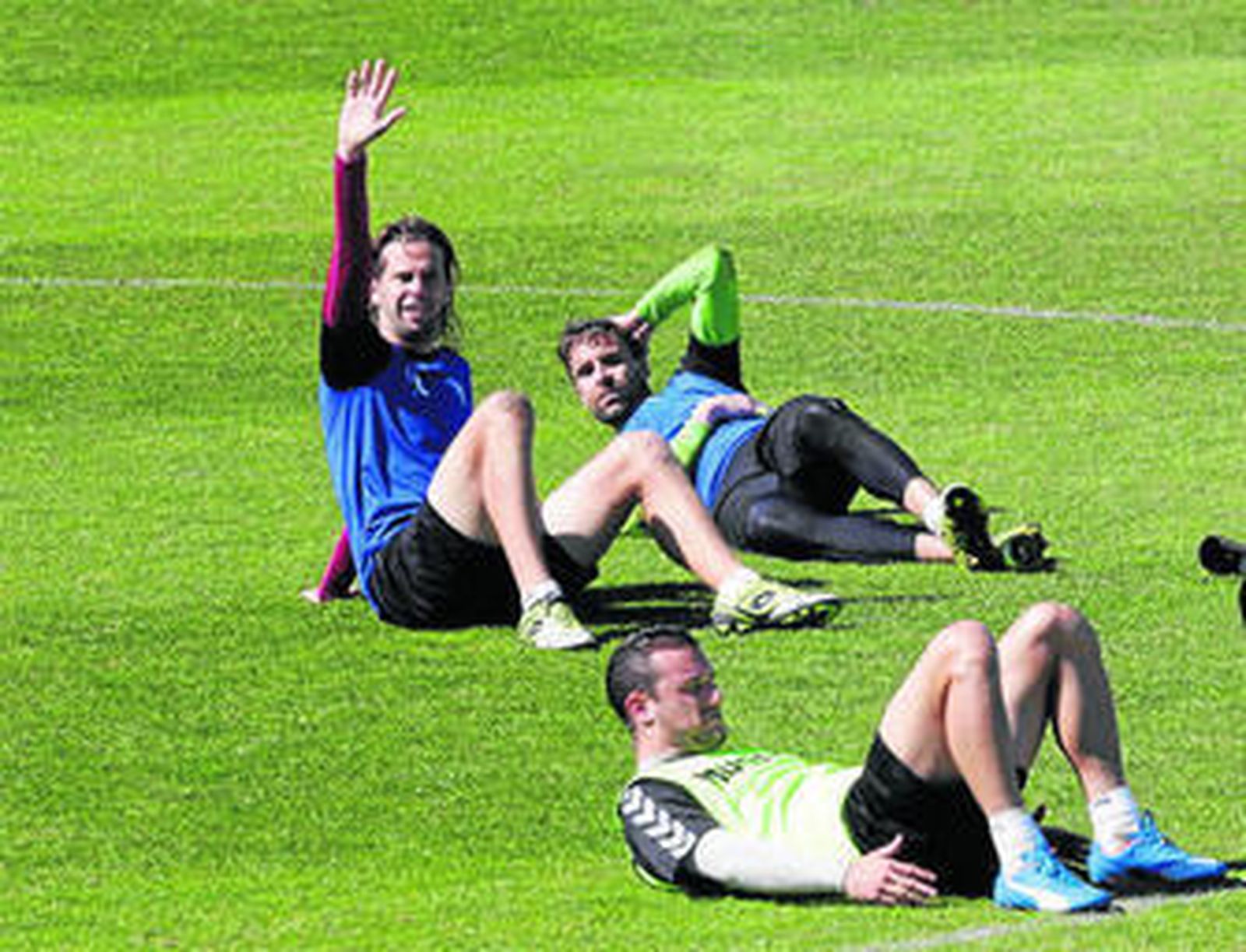 David Sánchez levanta un brazo mientras realiza la sesión de estiramiento al acabar un entreno.