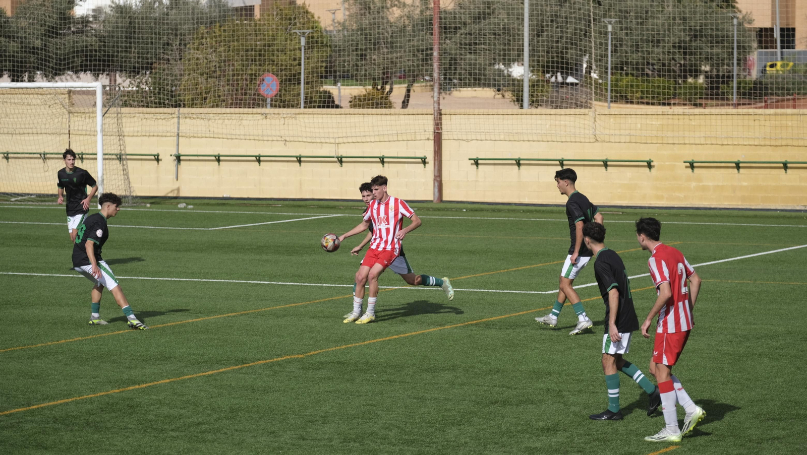 Un jugador del conjunto rojiblanco trata de controlar el balón ante la presión de un rival.
