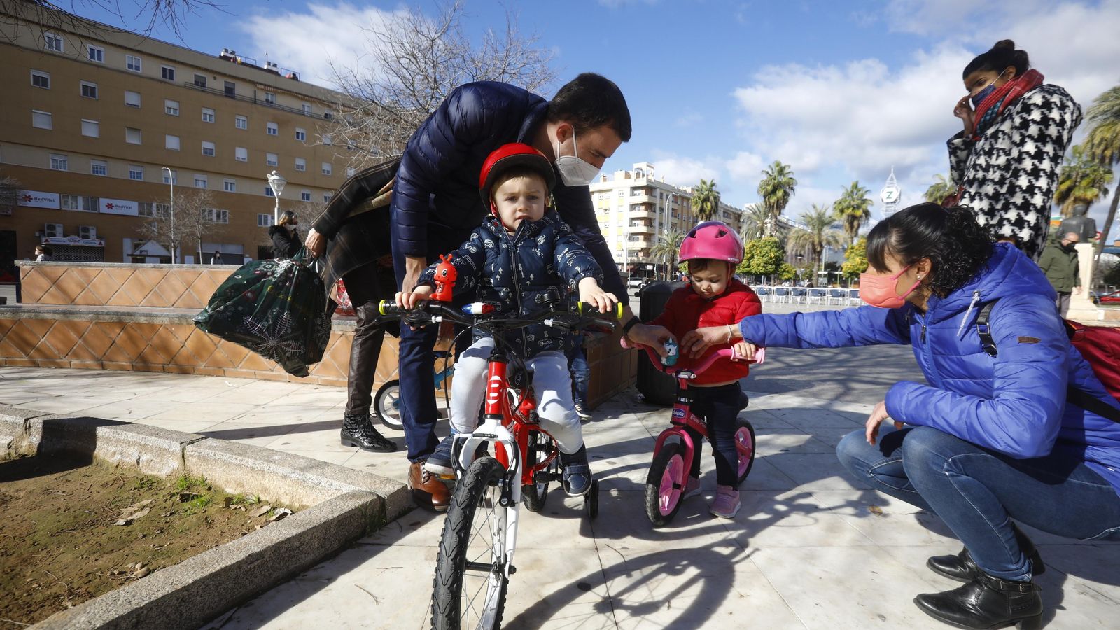 Antonio Jesús y Victoria preparan las bicicletas de sus hijos.