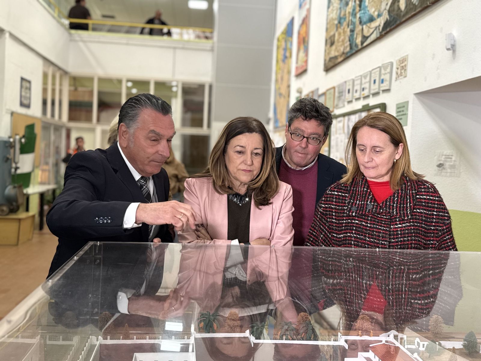 El director del IES Virgen del Carmen muestra la antigua maqueta del centro a la consejera, al delegado y a la alcaldesa