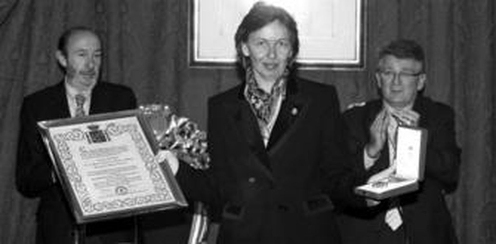 Liliane Dahlman, viuda de la duquesa de Medina Sidonia, muestra los reconocimentos a su esposa, ante el aplauso de Pérez Rubalcaba y González Cabaña.