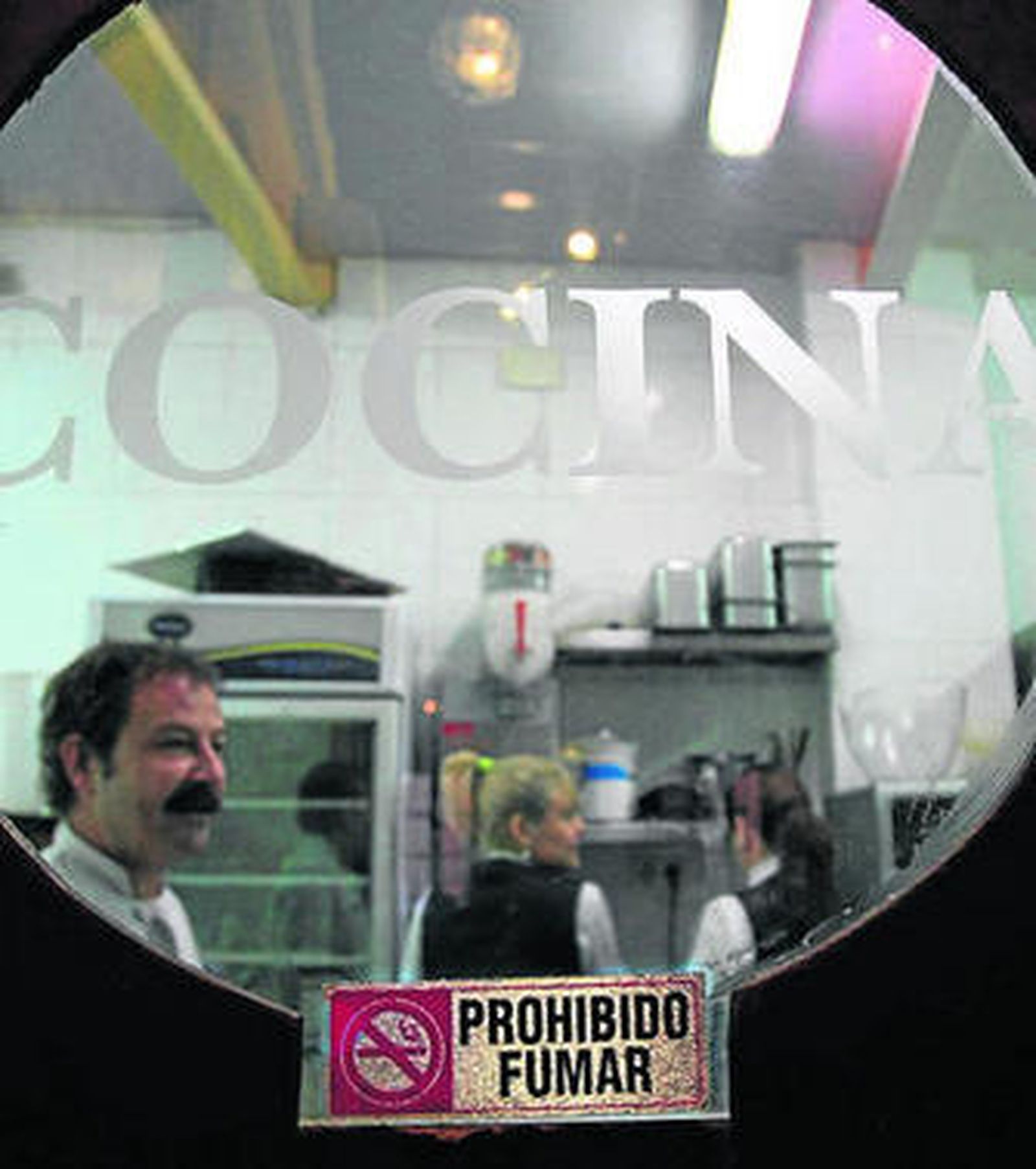 Cartel de prohibido fumar en la puerta de la cocina de un restaurante.