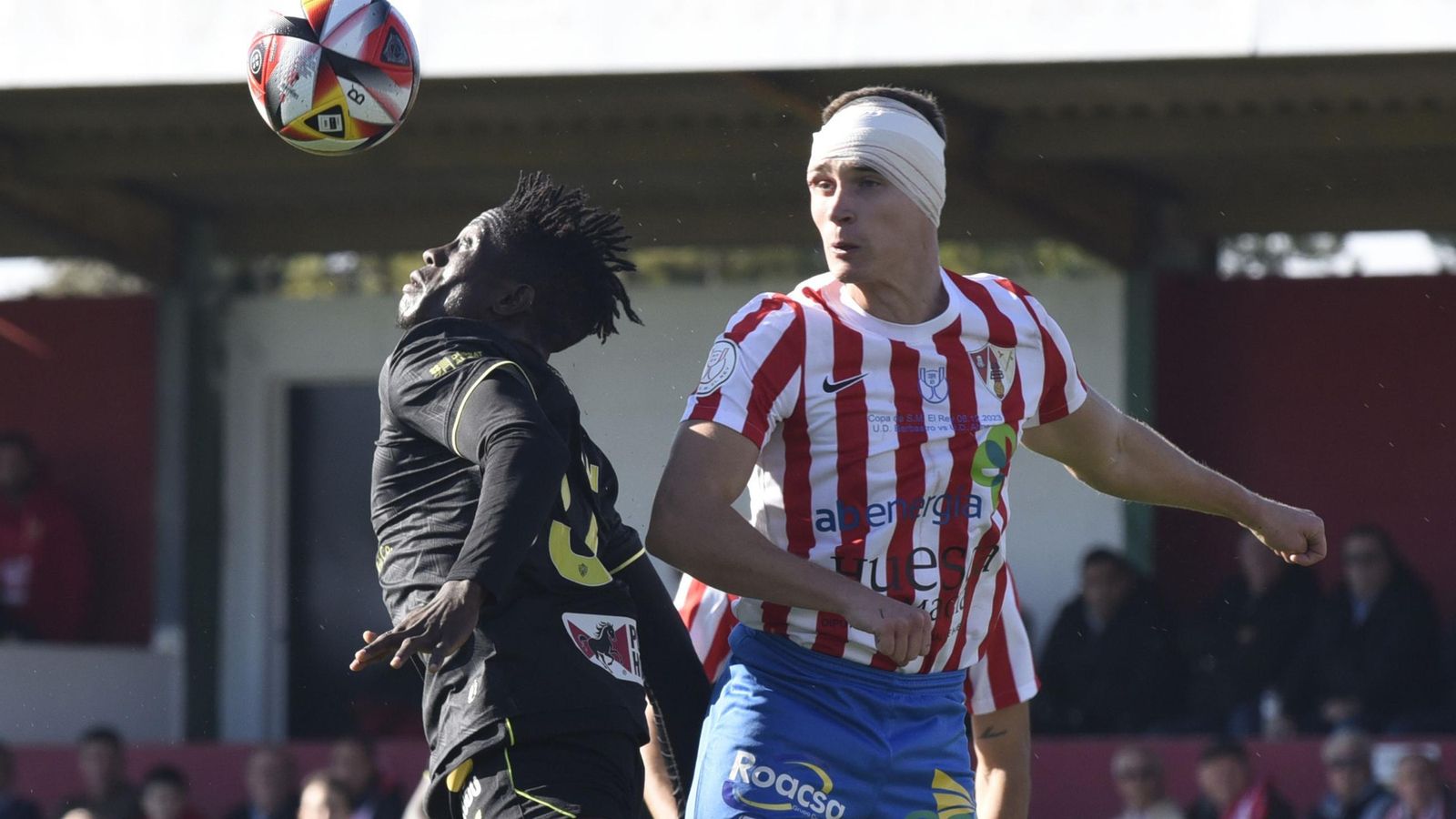 Marciano disputa un balón aéreo con un rival del Barbastro con un aparatoso vendaje