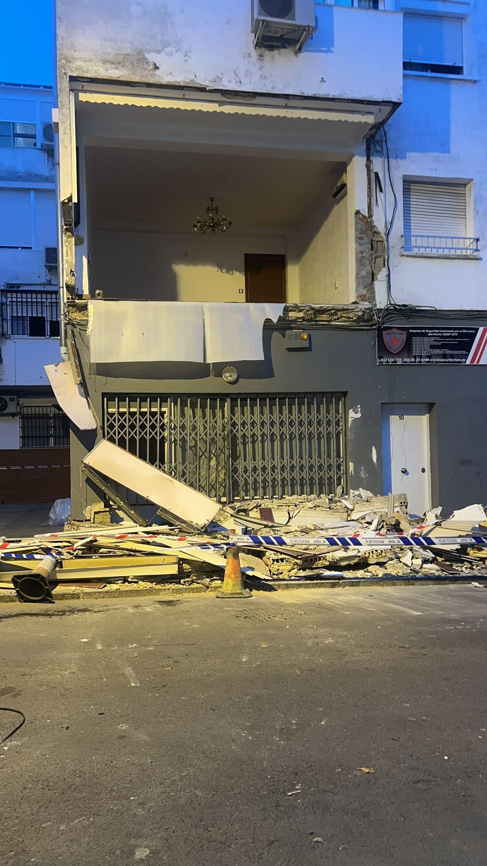 Imagen de la vivienda con los restos del balcón desprendido en la vía pública. Imagen de la vivienda con los restos del balcón desprendido en la vía pública.