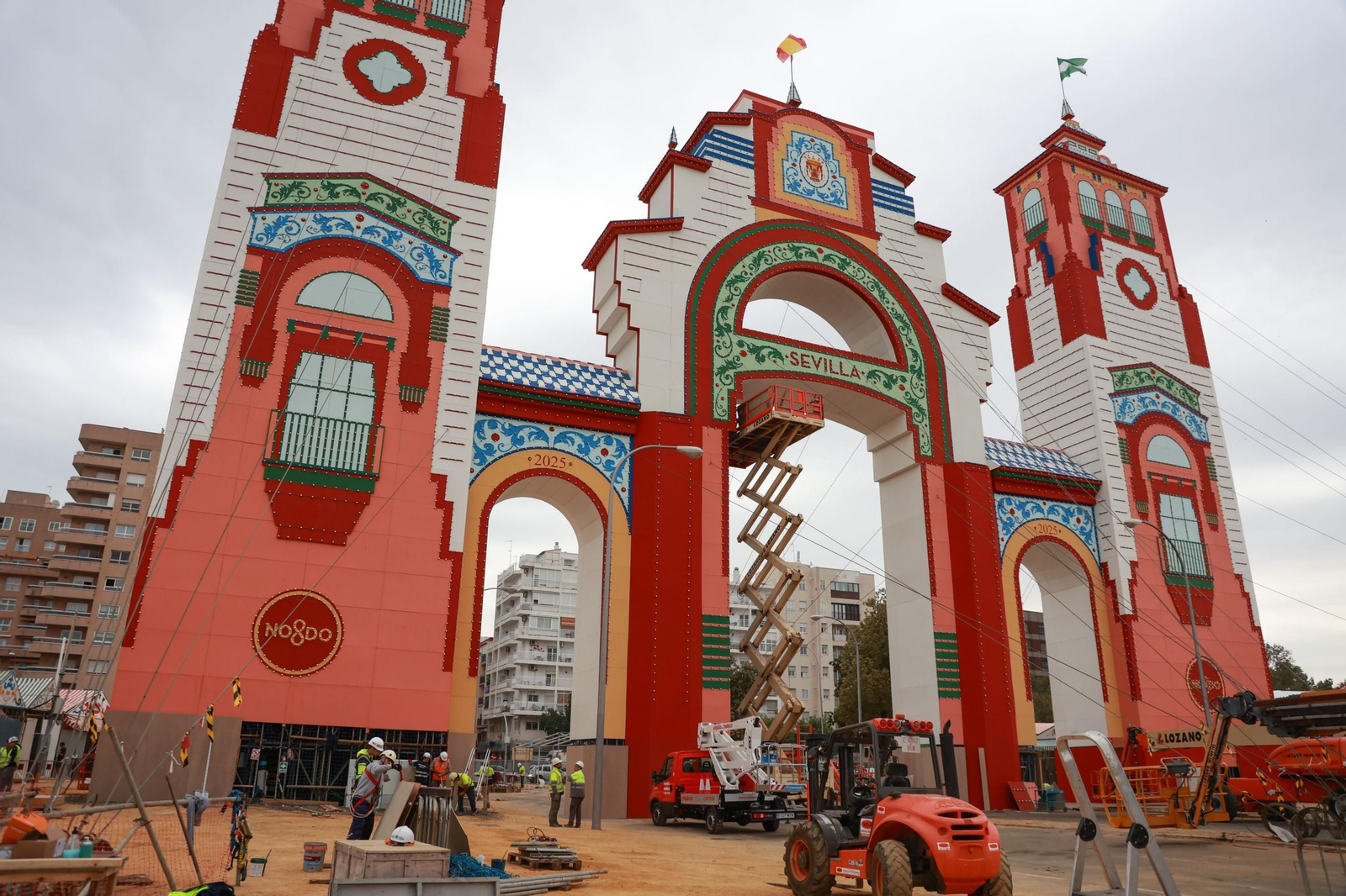 Varios trabajadores durante el montaje de la portada de la Feria de Sevilla.