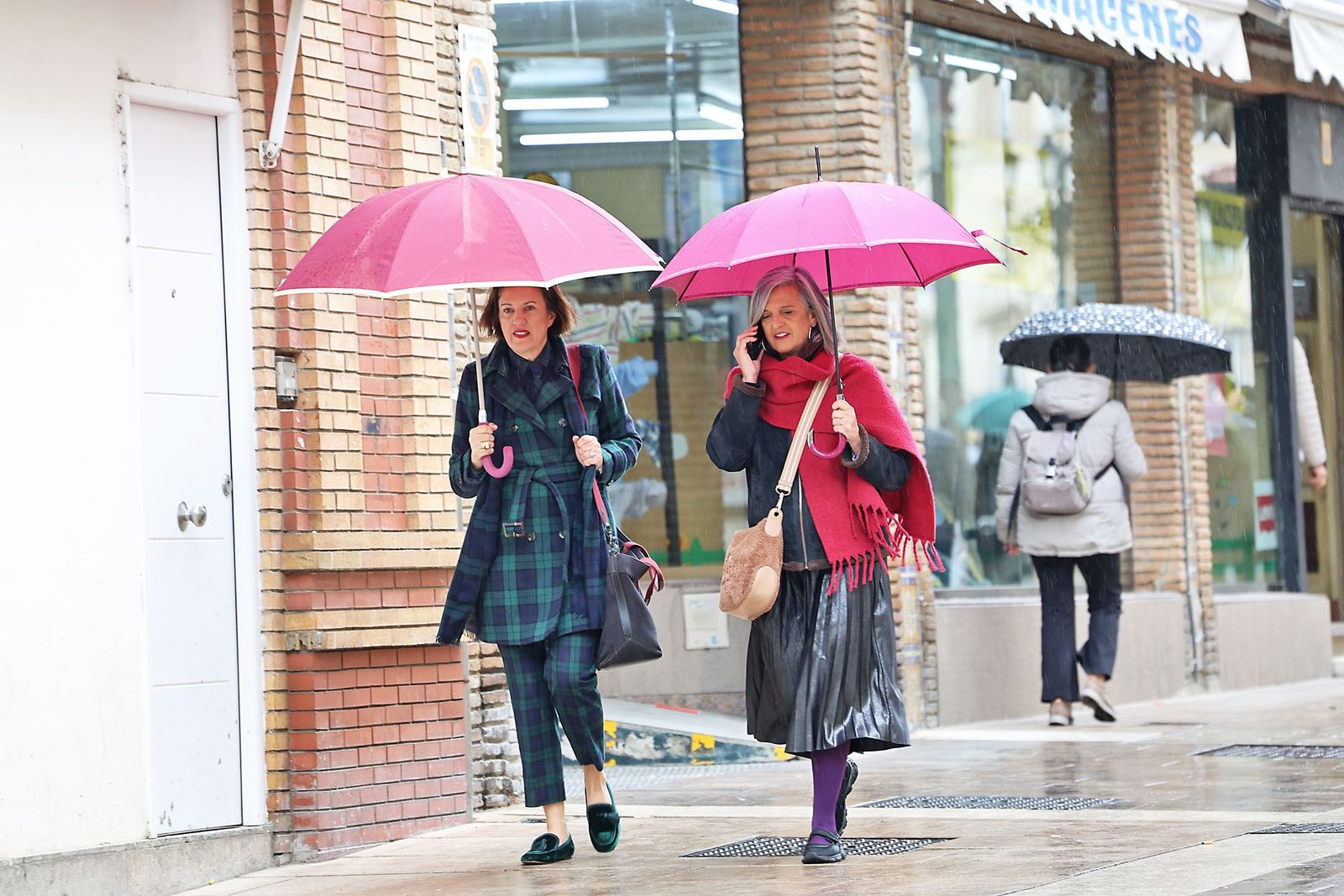 Varias personas con paraguas durante un chubasco en Huelva.