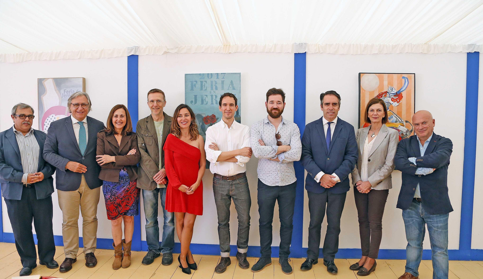 Artistas, organizadores y representantes municipales posan durante el montaje de las obras en la caseta.