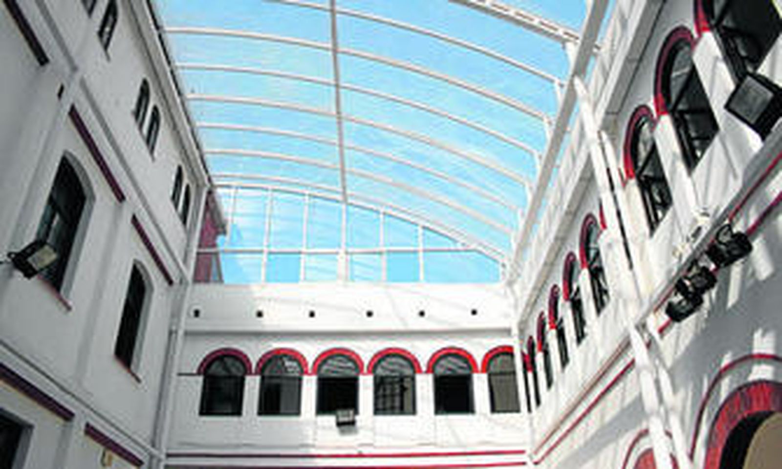 Patio interior con arcadas y columnas cubierto por una bóveda de metacrilato, desde el que se accede a la interesante escalera.