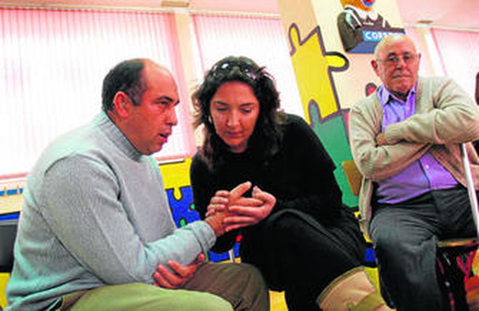 Una monitora se comunica con un discapacitado sensorial mediante señales en las palmas de las manos.