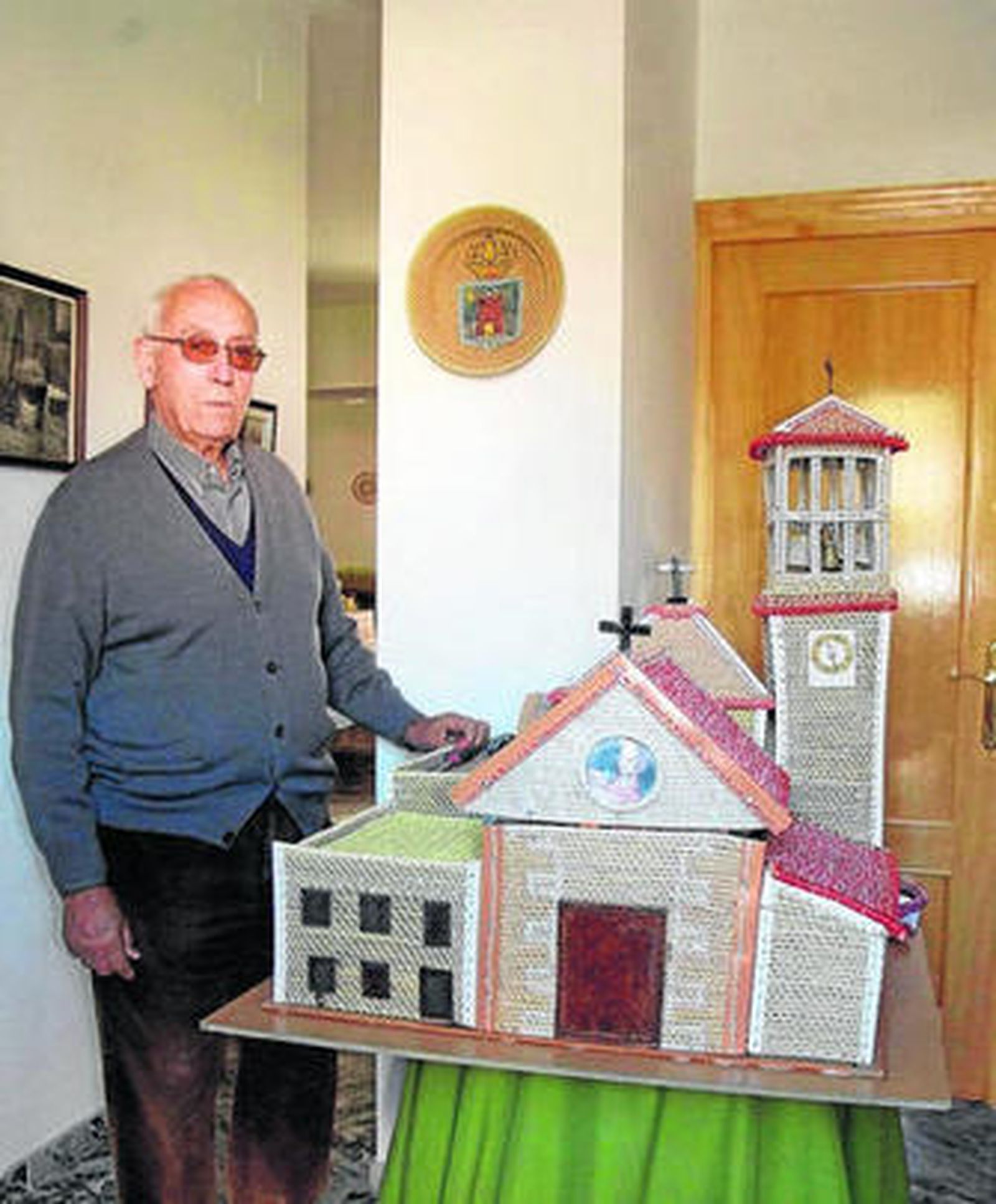 José Ruiz Villegas con la iglesia de la Virgen del Rosario de Roquetas que ha realizado con rafia.