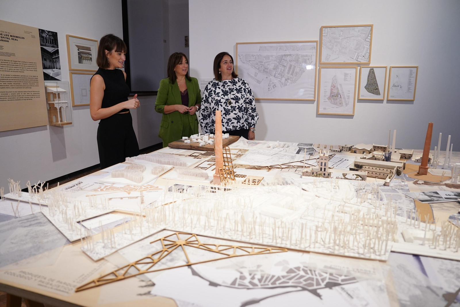 La comisaria comenta un de las maquetas de la muestra.