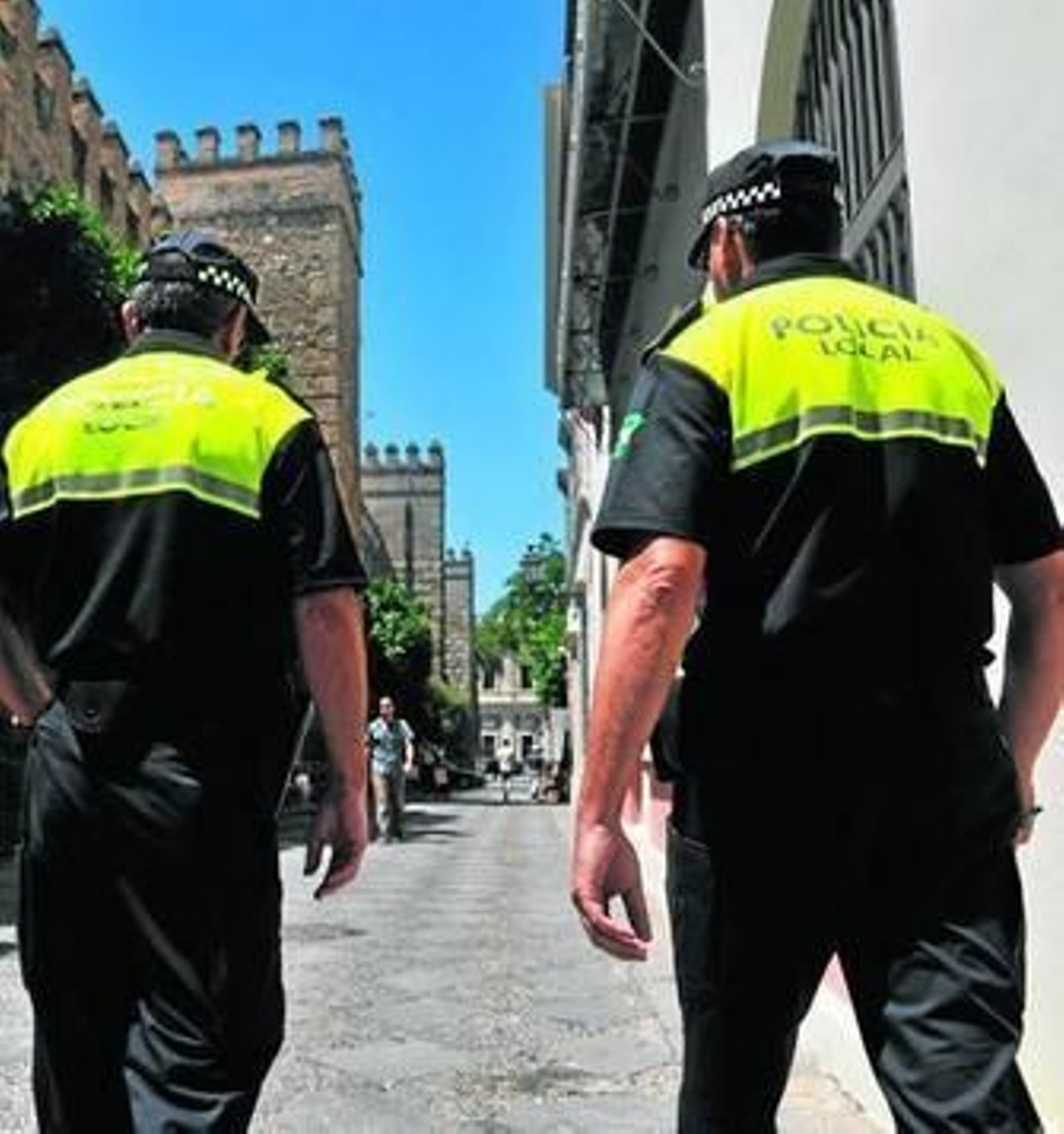 Dos policías del Grupo Giralda patrullan por el Patio de Banderas.