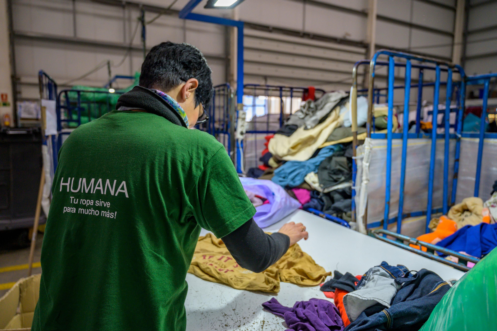 Un operario de la Fundación Humana Pueblo para Pueblo clasifica y ordena la ropa reciclada. Un operario de la Fundación Humana Pueblo para Pueblo clasifica y ordena la ropa reciclada.