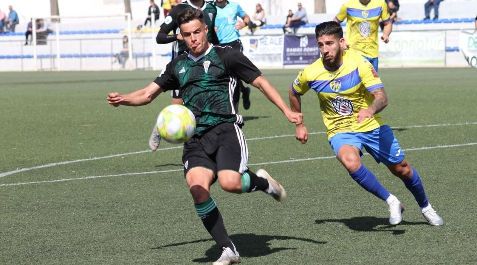 Samu González despeja el balón en presencia de un jugador del Conil.