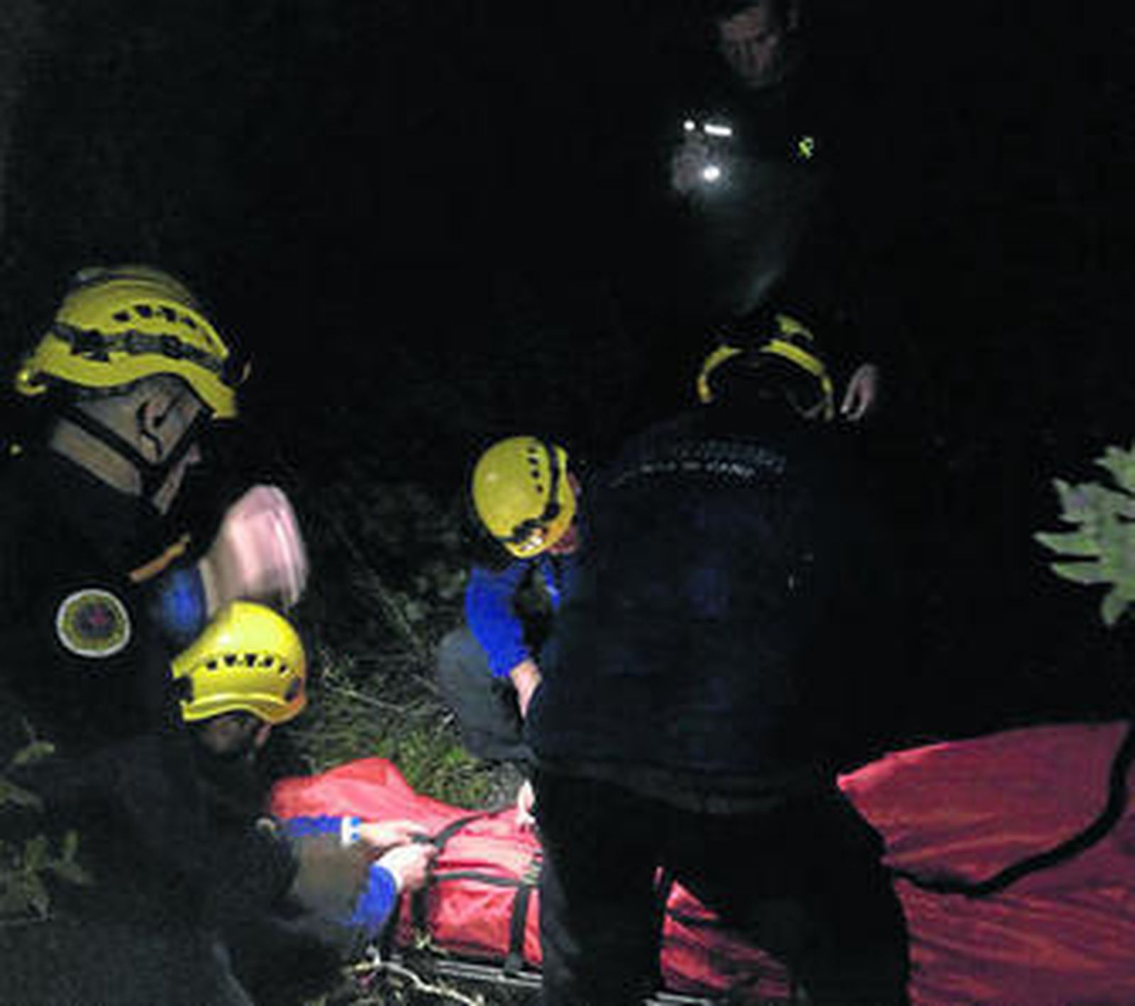 Momento del rescate del cuerpo, que cayó en una zona de monte escarpada.