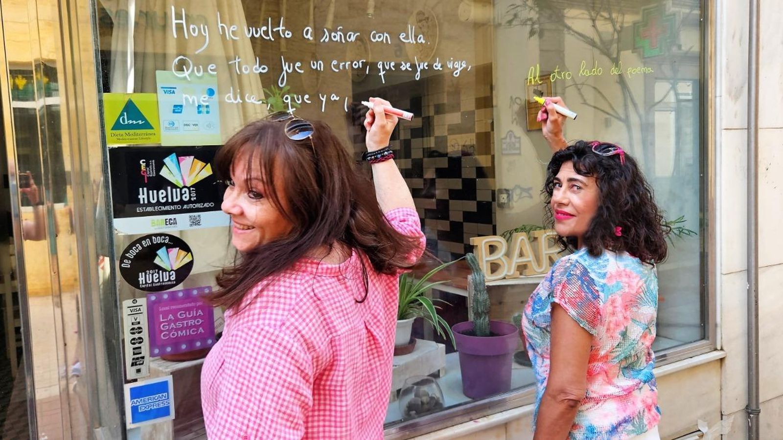 Dos mujeres participa en la pintura en escaparates.