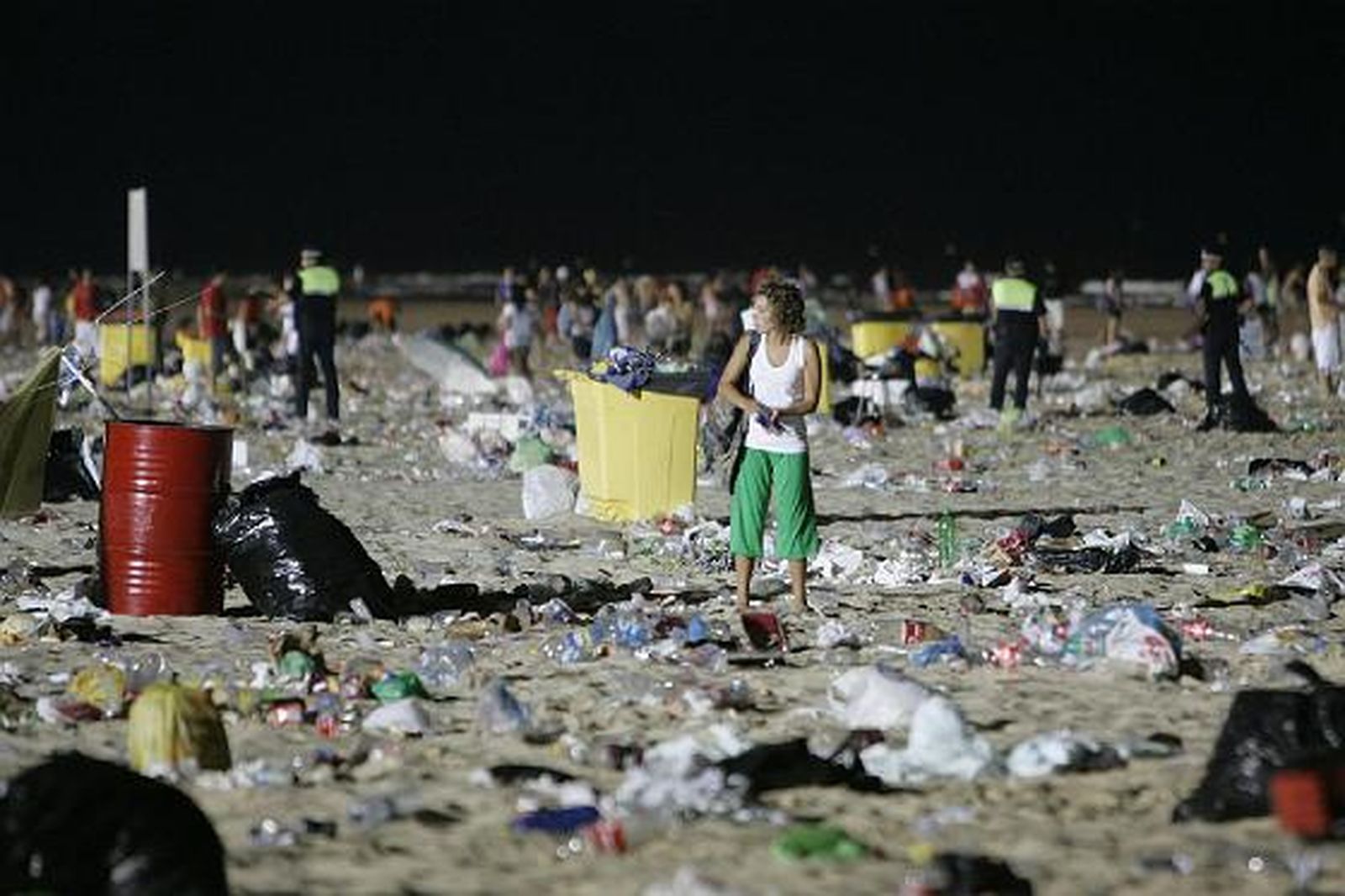 Una joven parece perdida entre bolsas de plástico, botellas y restos de comida.   Foto: Lourdes de Vicente