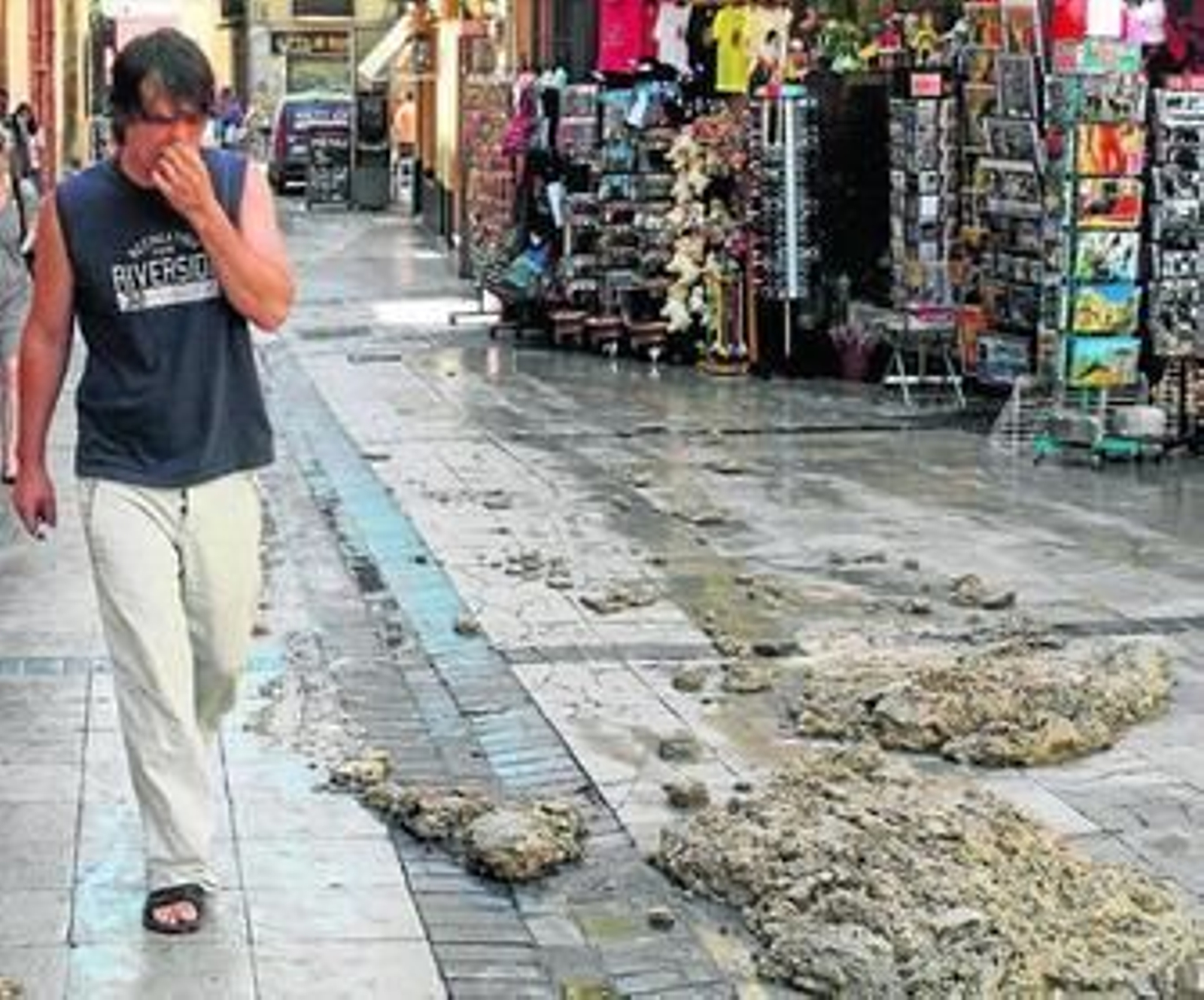 Un hombre se tapa la nariz por el fuerte olor, ayer, en la calle Granada.