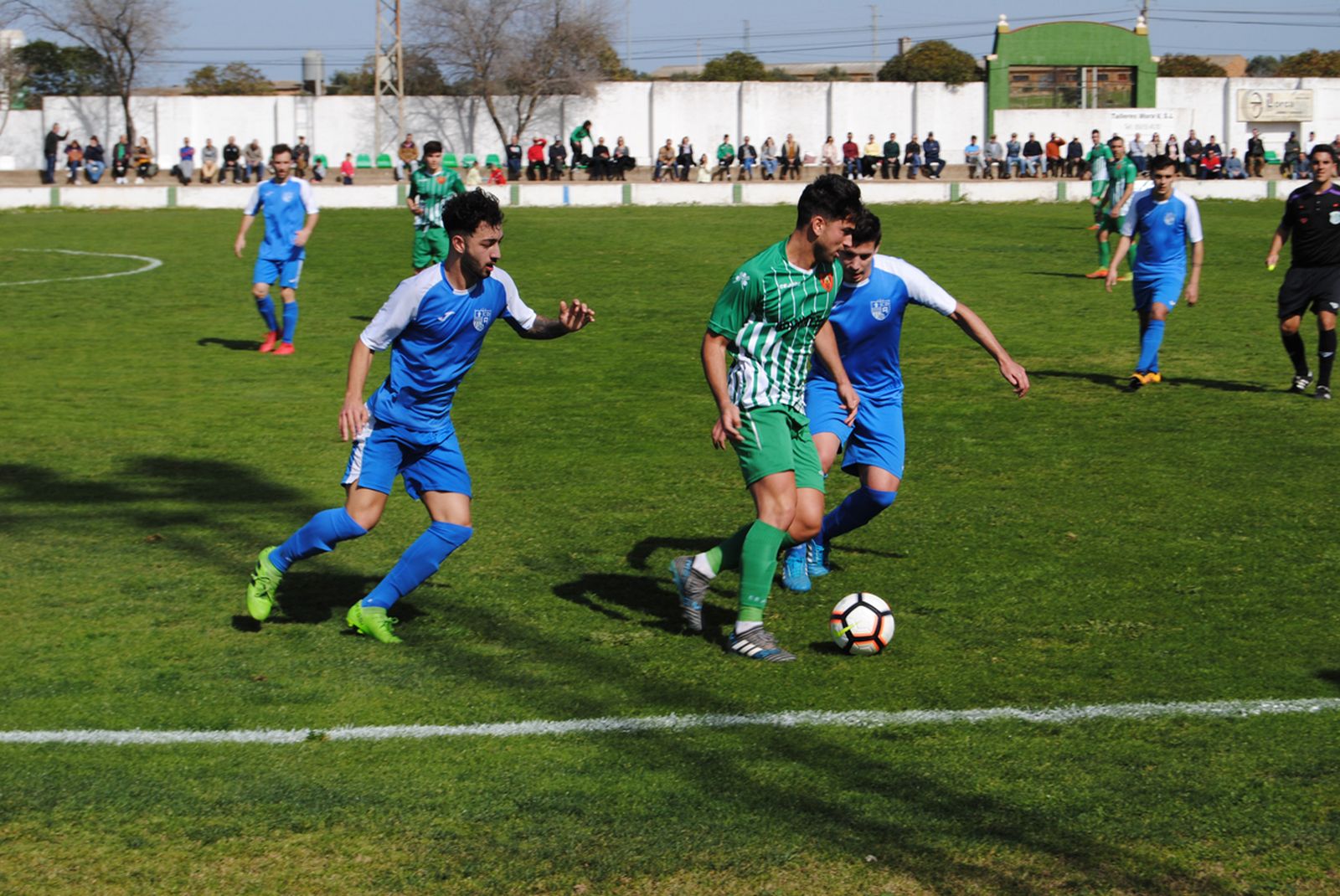 El valverdeño Samu conduce la pelota perseguido por dos jugadores del Alcalá.