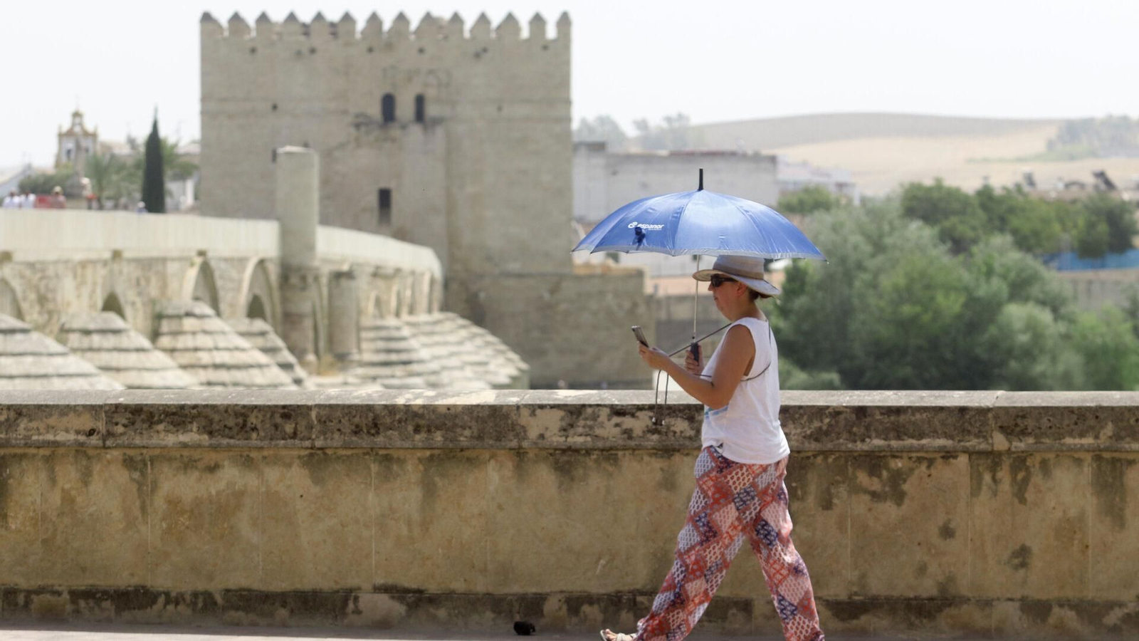 Una mujer se protege del sol durante una ola de calor del mes de julio. Una mujer se protege del sol durante una ola de calor del mes de julio.