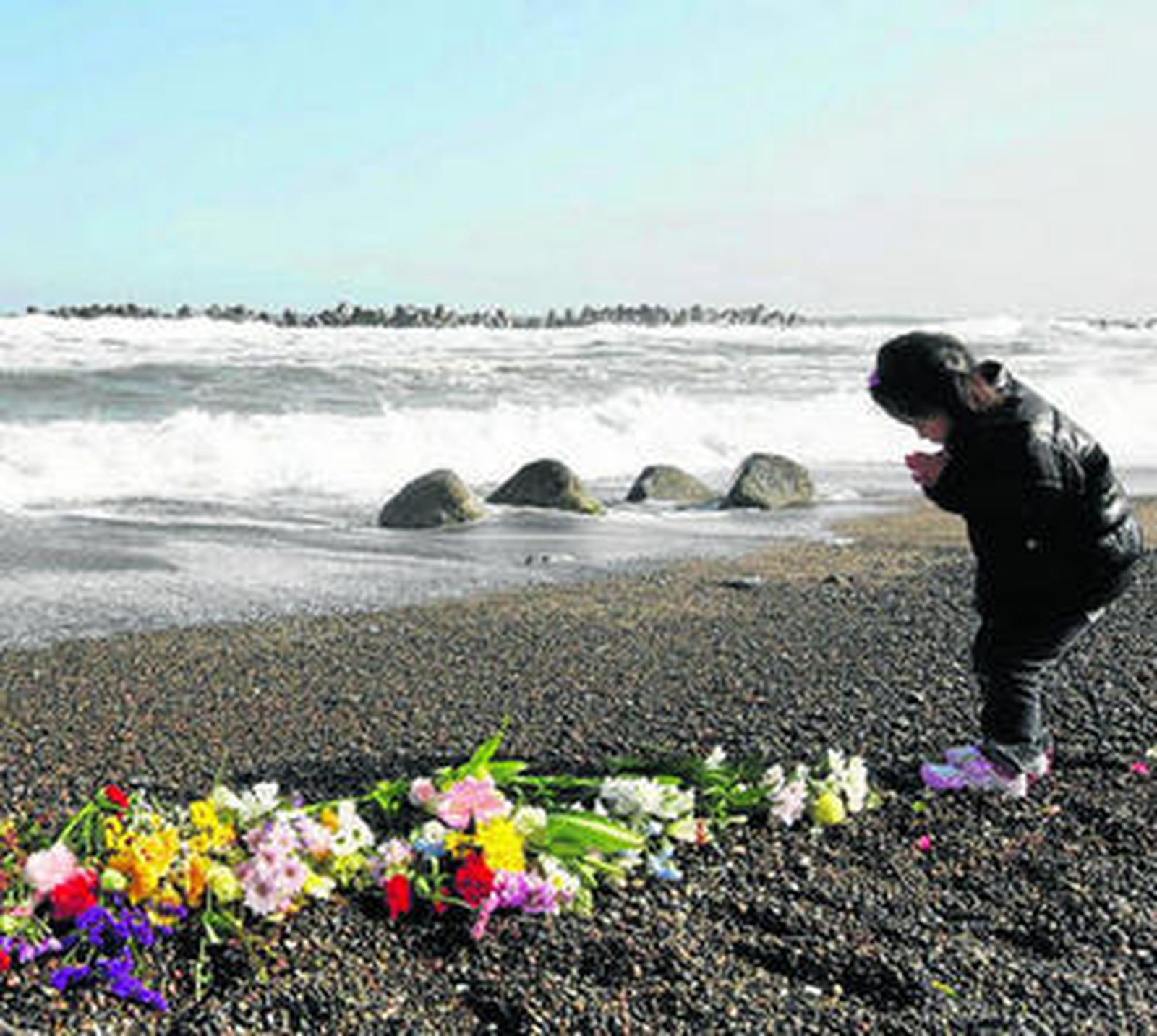 Una niña reza por las víctimas en la bahía de Fukushima en el aniversario del 'tsunami'.