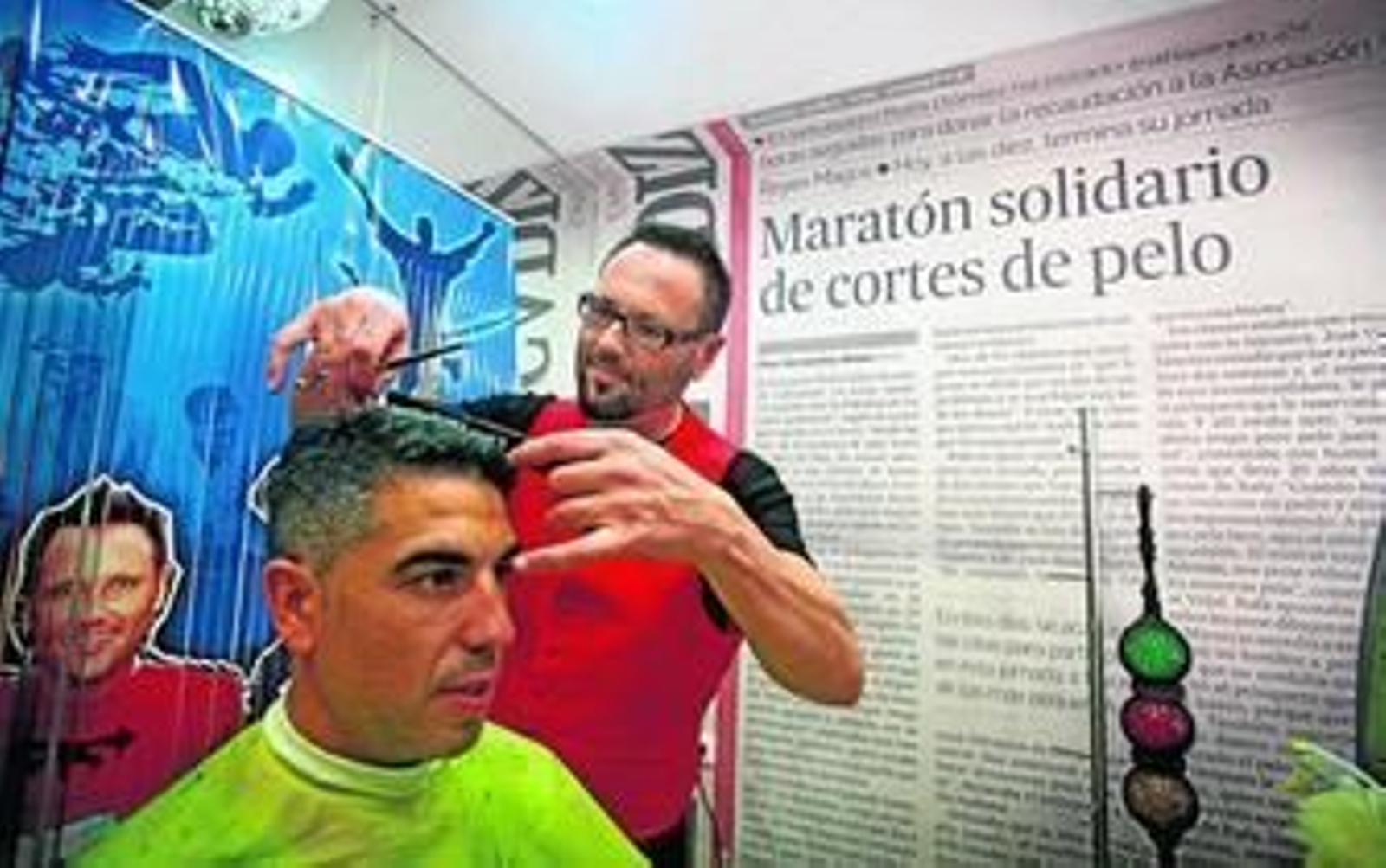 Rafa Gómez cortando el pelo ayer a uno de sus clientes solidarios en su peluquería de la calle Pintor Zuloaga.